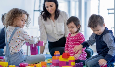 Childcare worker playing with small children