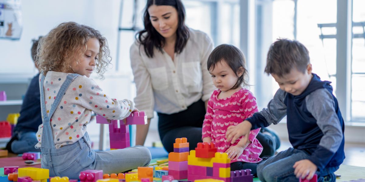 Childcare worker playing with small children