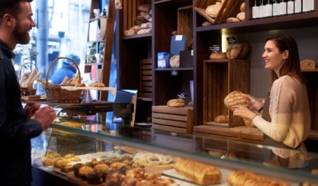 woman serving customer at a small bakery used on a page about business continuity insurance